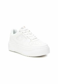 Zapatilla blanca con suela gruesa, puntera perforada y panel lateral texturizado. Cuenta con cordones y un pequeño logotipo en el lado y en la lengüeta.