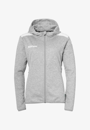 Grijze ritsjack met capuchon, voorzien van witte schouderaccenten en het "Kempa" logo op de borst. Zacht, gestructureerd materiaal.