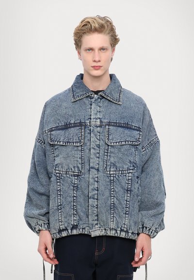 Spijkerjack in een lichtblauwe tint, met vier voorzakken en een elastische tailleband. Heeft een traditionele kraag en geribbelde details op de mouwen.