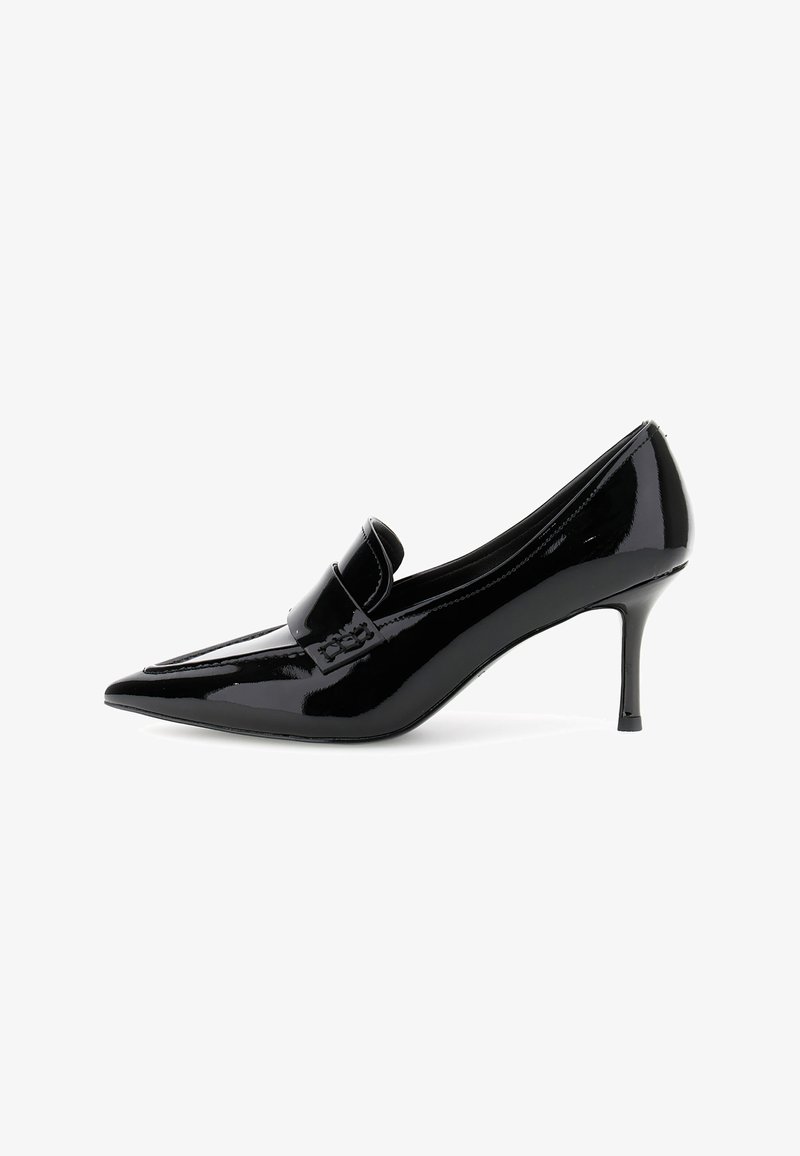 Scarpa nera in vernice con tacco alto e punta affilata, con un dettaglio a fiocco sulla tomaia, caratterizzata da un tacco sottile di 7,5 cm.