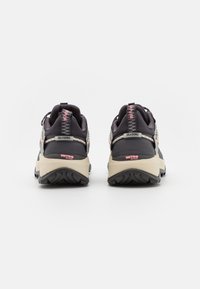 Czarno-tanowe sneakersy z tkaninową cholewką, teksturowanymi akcentami i grubą gumową podeszwą. Posiadają różowe logo na pięcie i języku.
