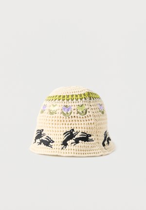 Krémový háčkovaný klobúk s vyšívanými zelenými a fialovými kvetmi a čiernymi motívmi zajacov okolo krempy.