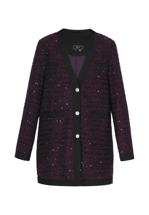 Violetti neulecardigan, jossa on metallilangat, mustat yksityiskohdat ja kolme koristepainiketta. Kaksi etutaskua ja V-pääntie.