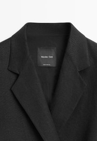 Zwart op maat gemaakte colbertkraag met inkeping revers en een zichtbaar binnenlabel met de tekst "Massimo Dutti, Made in Portugal."