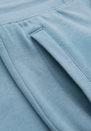 Vaaleansinistä neulosta, jossa on leveä joustava vyötärönauha ja pystysuora sivutaskun aukko.