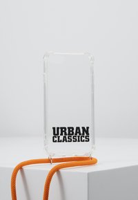 Transparent phone case with "URBAN CLASSICS" in bold black lettering; includes a bright orange lanyard for easy carrying.