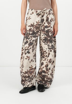 Pantalon large en tissu beige clair avec un motif abstrait marron foncé et noir. Taille élastique avec cordon de serrage ajustable.