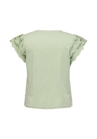 Haut vert clair à manches courtes avec détails en dentelle festonnée sur les manches, encolure ronde et dos uni.
