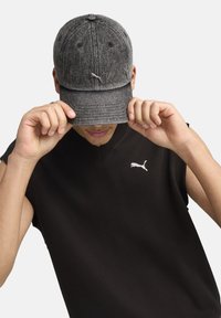 Gray textured cap with rounded brim, featuring a logo on the front. Black sleeveless top with a small logo on the chest.