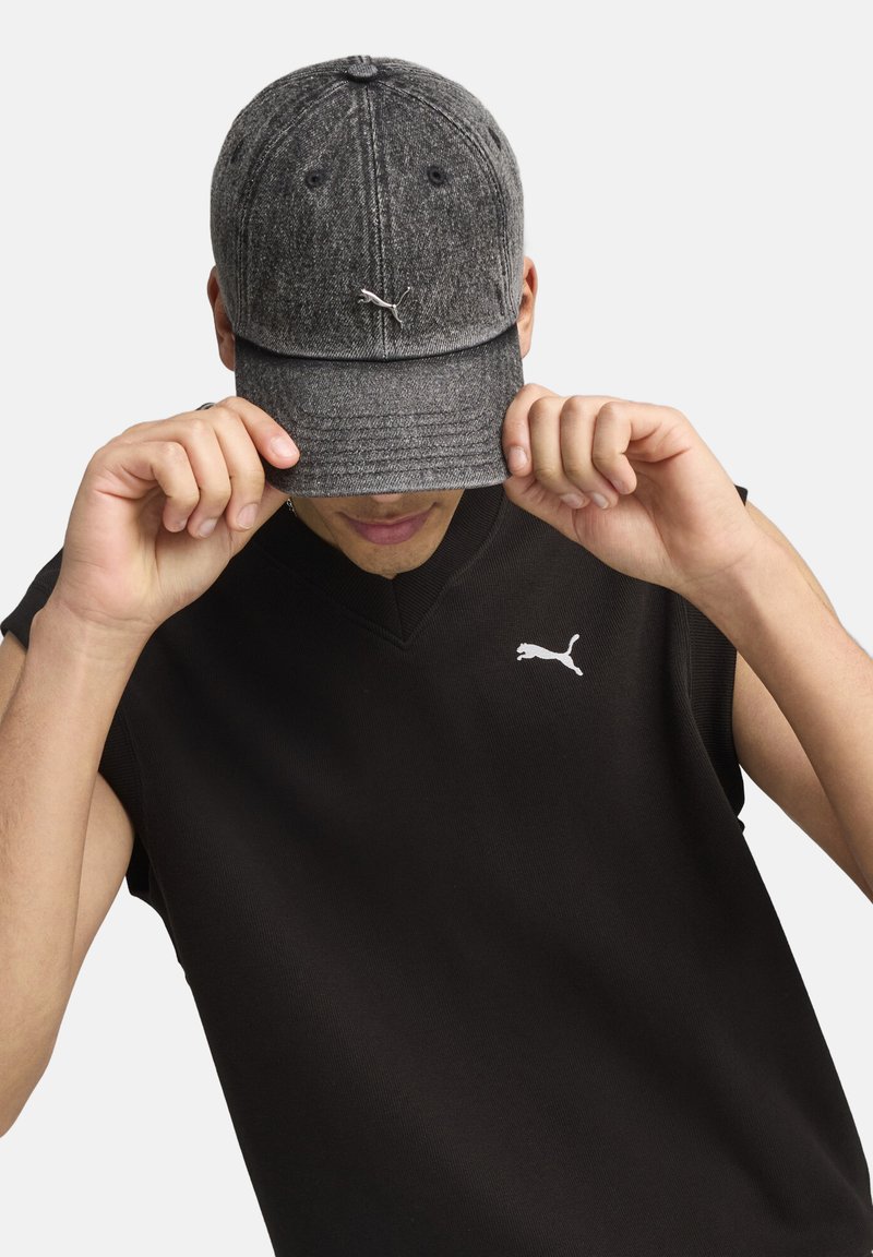 Gray textured cap with rounded brim, featuring a logo on the front. Black sleeveless top with a small logo on the chest.