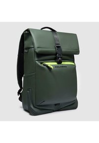 Mochila impermeable verde con cierre superior plegable, cierre de hebilla negra y un bolsillo frontal con cremallera en amarillo neón. Cuenta con detalles texturizados y correas acolchadas.