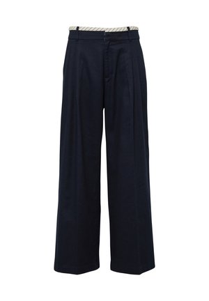 Marineblaue, weit geschnittene Hose mit Falten, Gürtelschlaufen und einem hellen Bunddetail.