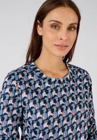 Katoenen sweatshirt met een multikleurig patroon van halfronde vormen in blauw, roze, crème en marineblauw. Ronde hals en lange mouwen.