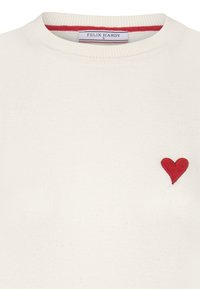 Biały bawełniany sweter z prążkowanym dekoltem, ozdobiony małym, czerwonym haftowanym sercem na lewej piersi oraz subtelnym czerwonym wykończeniem wewnątrz kołnierza.