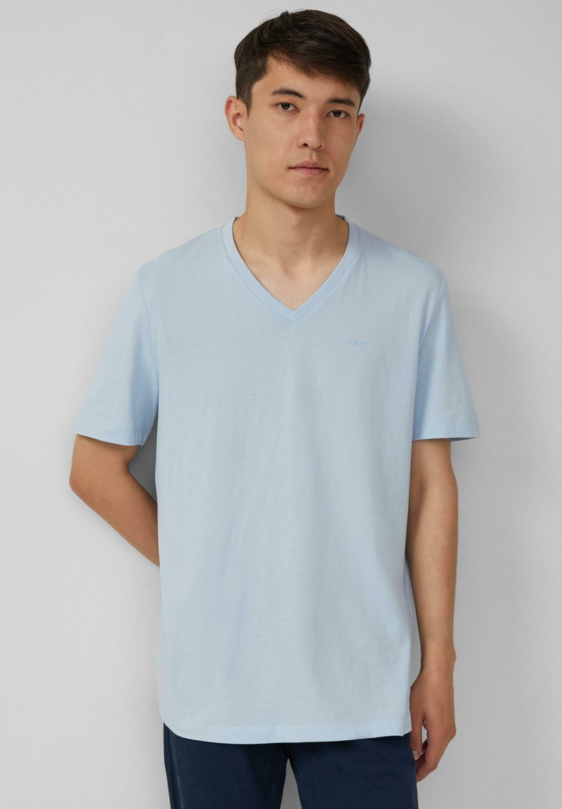 Lichtblauwe V-hals t-shirt, korte mouwen, zachte katoenen textuur, lichte logo-detail op de borst, relaxte pasvorm, casual ontwerp.