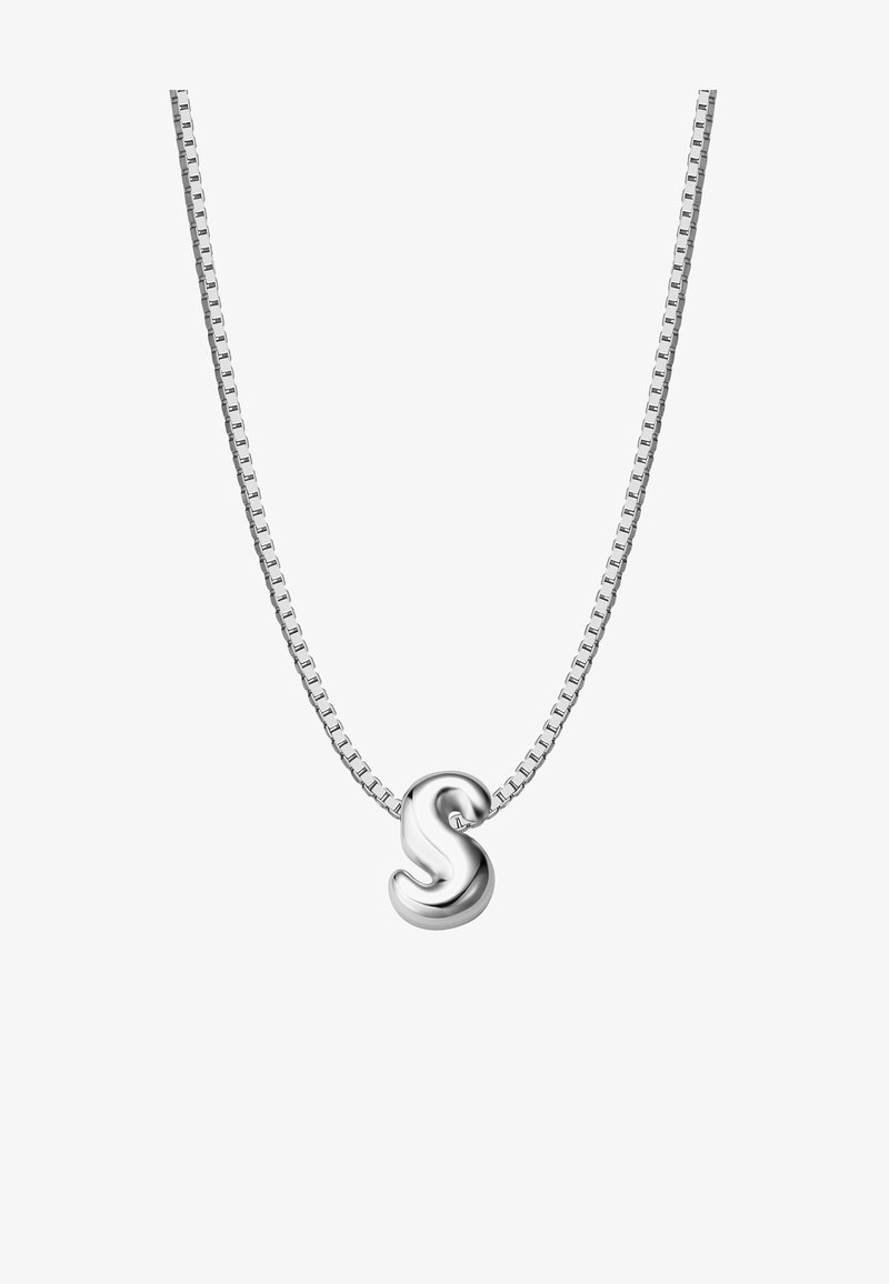 Sudraba ķēdes kaklarota ar gludu, stilizētu burta "S" piekariņu. Ķēdei ir segmentēts dizains, kas piešķir papildu tekstūru.