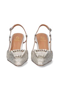Zapatos slingback plateados con punta afilada, tela texturizada y un acento joya en la parte delantera. Plantilla de cuero en tono marrón.