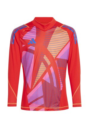 Chemise longue à manches rouges avec des motifs abstraits en rose, orange et bleu. Fabriquée en matériau léger avec un col montant et des coutures contrastantes.