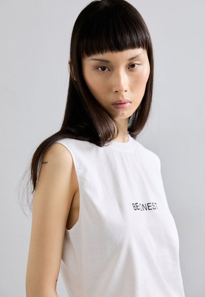 Weißes ärmelloses Baumwoll-T-Shirt mit schwarzem Text, der "BEONEST" lautet. Glatte Textur mit einem einfachen, minimalistischen Design.