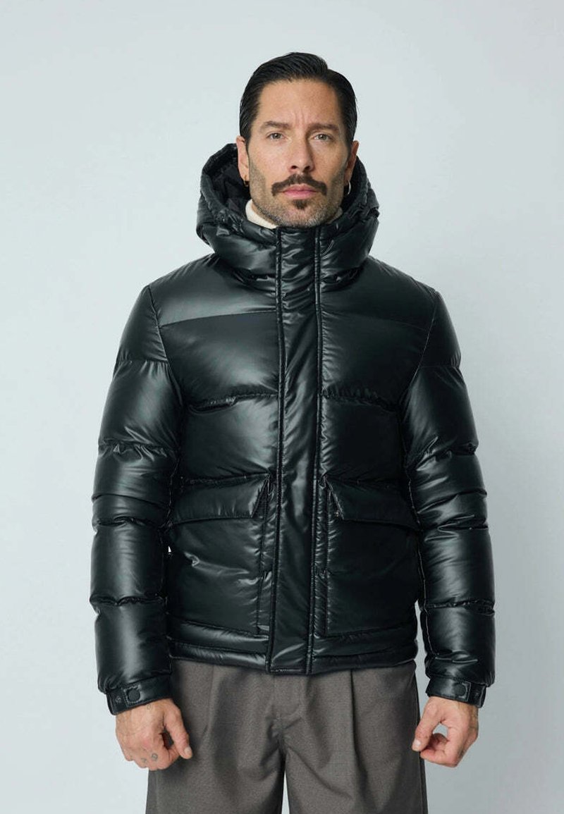 Veste noire rembourrée avec un col haut et une capuche, présentant une finition brillante et deux poches avant, conçue avec des panneaux cousus.