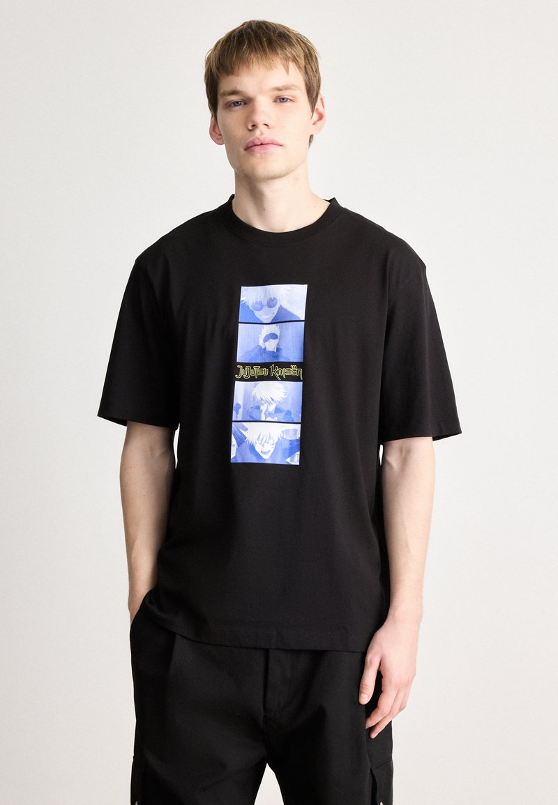 Μαύρο βαμβακερό μπλουζάκι με γραφικό τύπωμα σε μπλε αποχρώσεις και κείμενο σε ορθογώνιο σχέδιο στο μπροστινό μέρος. Κοντά μανίκια και χαλαρή εφαρμογή.