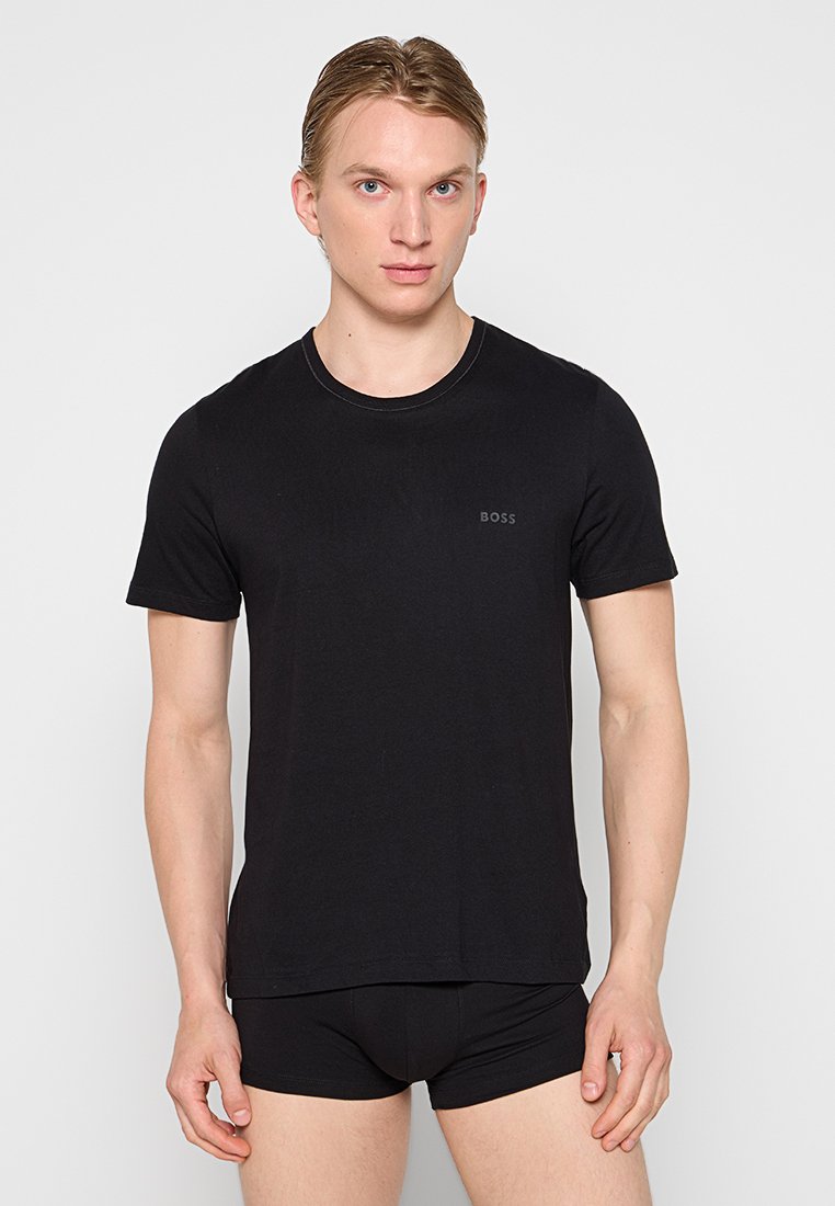 T-shirt noir à col rond en coton doux avec des manches courtes, présentant un logo "BOSS" subtil sur la poitrine.