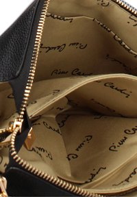 Borsa in pelle nera con zip dorata che rivela un interno in tessuto beige stampato con la scritta ripetuta "Pierre Cardin".