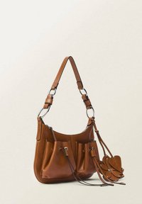 Sac à épaule en cuir marron avec poches à double pochette, bandoulière ajustable et accent floral décoratif. Texture lisse et forme arrondie.