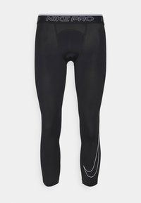 Czarne legginsy Nike Pro o dopasowanym kroju, charakteryzujące się gładką fakturą, białym akcentem w postaci logo Swoosh oraz elastycznym pasem z logo.