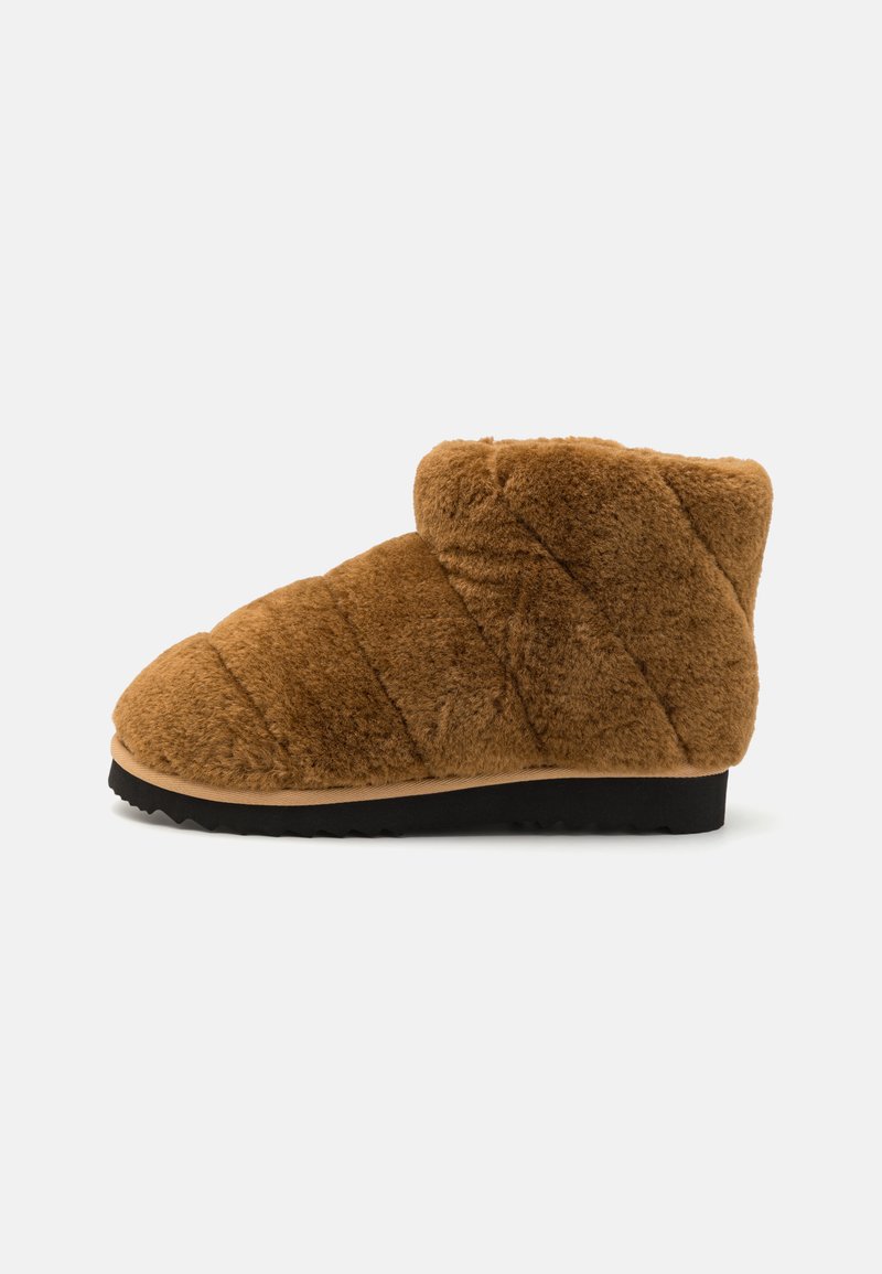 Pruunist plush-bootsist, millel on tikitud muster, ümar varvas, pehme tekstuur ja must kummitald, pakkudes sooja ja mugavat disaini.