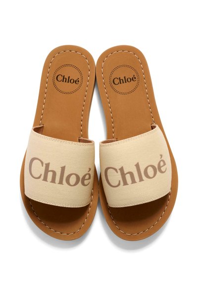 Płaskie klapki ze skóry w kolorze jasnobrązowym z szerokimi beżowymi paskami z tkaniny, z brązowym logo "Chloé" na paskach i wkładkach, widoczne przeszycia na krawędziach.