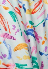 Tessuto bianco con vivaci colpi di pennello astratti in arancione, verde, rosa, blu, viola e rosso che si estendono su di esso.