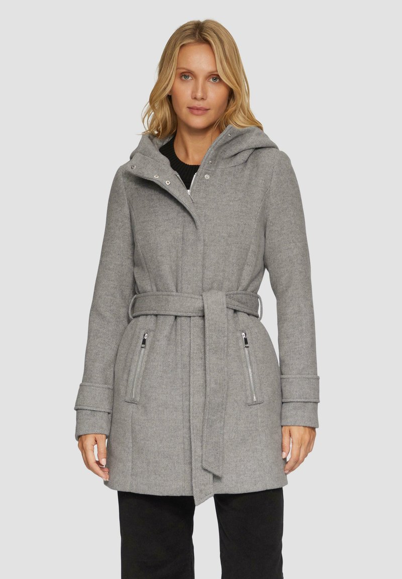 Manteau en laine gris avec une capuche, une taille ceinturée et des poches zippées. Présente une finition texturée et un design structuré.