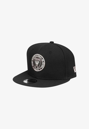 Schwarze Baseballmütze aus Stoff mit einem runden gestickten Logo, das "Club Internacional de Fútbol Miami" in Pink und "MMXX" darunter zeigt.