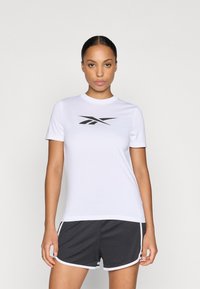 Tricou sportiv alb cu mâneci scurte și guler elastic, având un logo negru pe piept. Asociat cu pantaloni scurți gri închis cu dungi albe.