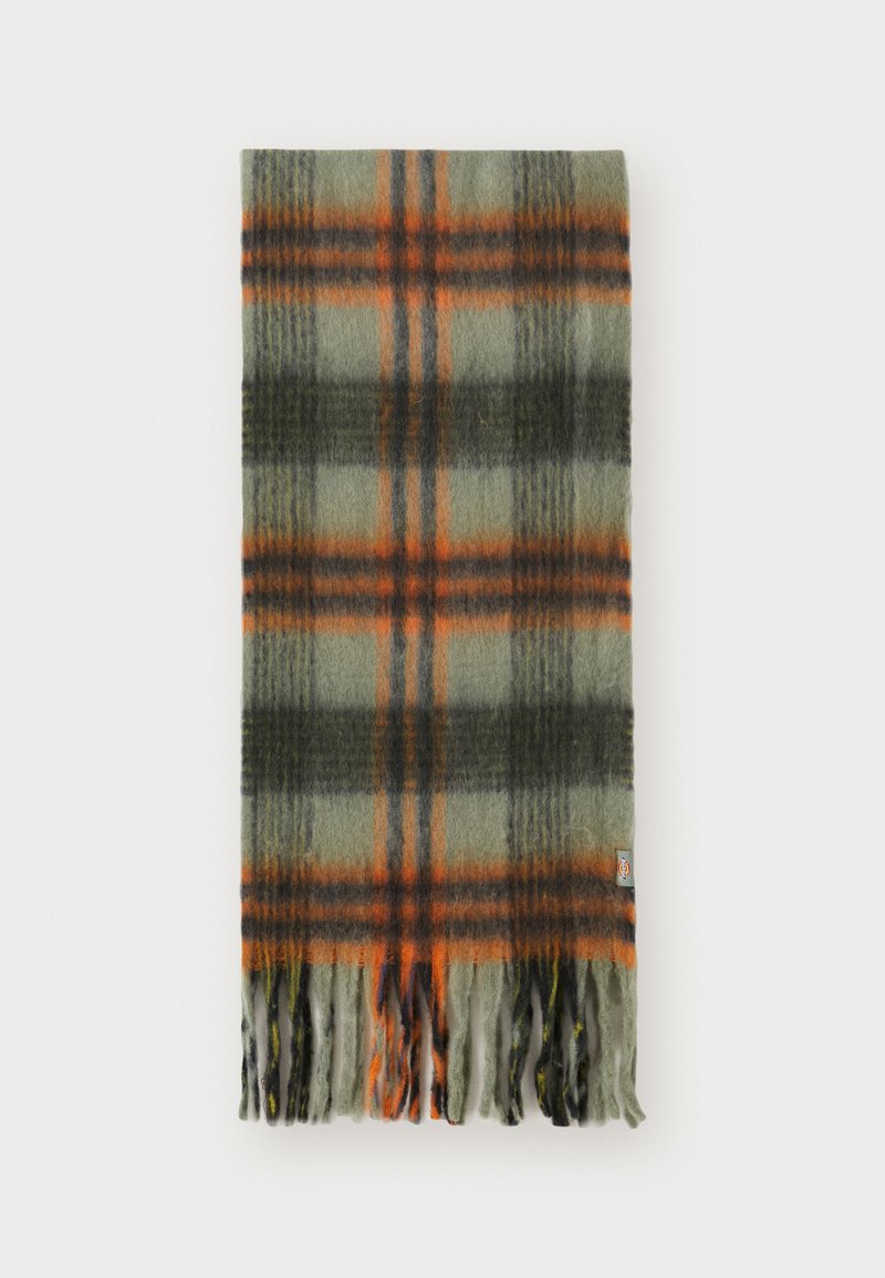Rutet skjerf i grønn, mørkegrå og oransje. Laget av en myk ullblanding, med frynsete kanter og en logo-lapp på den ene siden.
