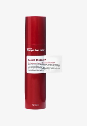 Punainen sylinterimäinen pullo kiiltävällä pinnalla, jossa on etiketti "Recipe for men Kasvojen puhdistusaine." Etuosassa on valkoinen ohjeetiketti.