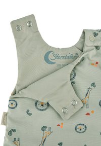 Hellgrüner Schlafsack mit Tiermustern, der Löwen und Giraffen zeigt. Mit silbernen Druckknöpfen verschlossen, aus weichem Stoff und mit gesticktem Logo.