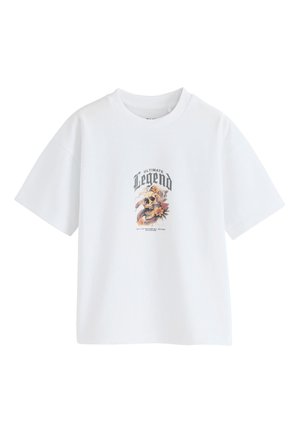 Bela majica s kratkimi rokavi z napisom "Ultimate Legend" nad grafiko lobanje, cvetlic in kače, potiskano na prsih.