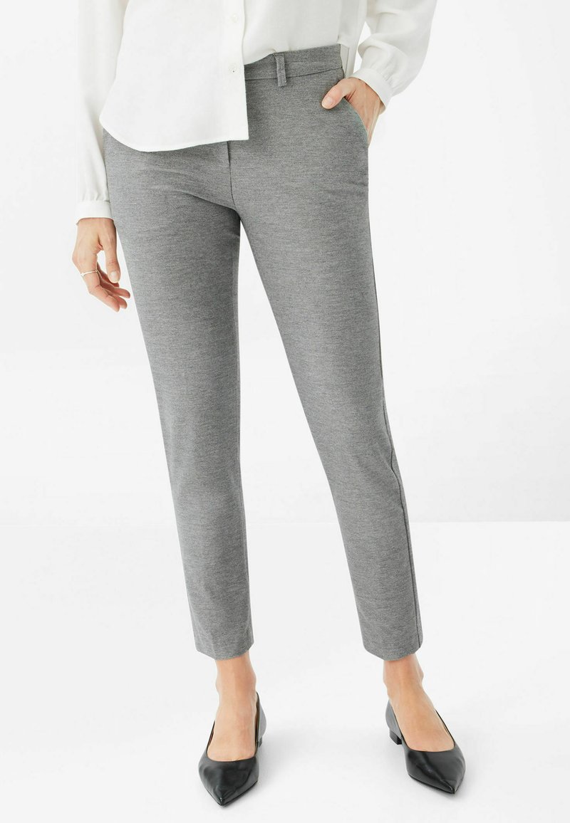 Grau, maßgeschneiderte Hose mit glatter Textur und schmaler Passform. Verfügt über einen flachen Bund und Seitentaschen. Kombiniert mit schwarzen spitzen High Heels.