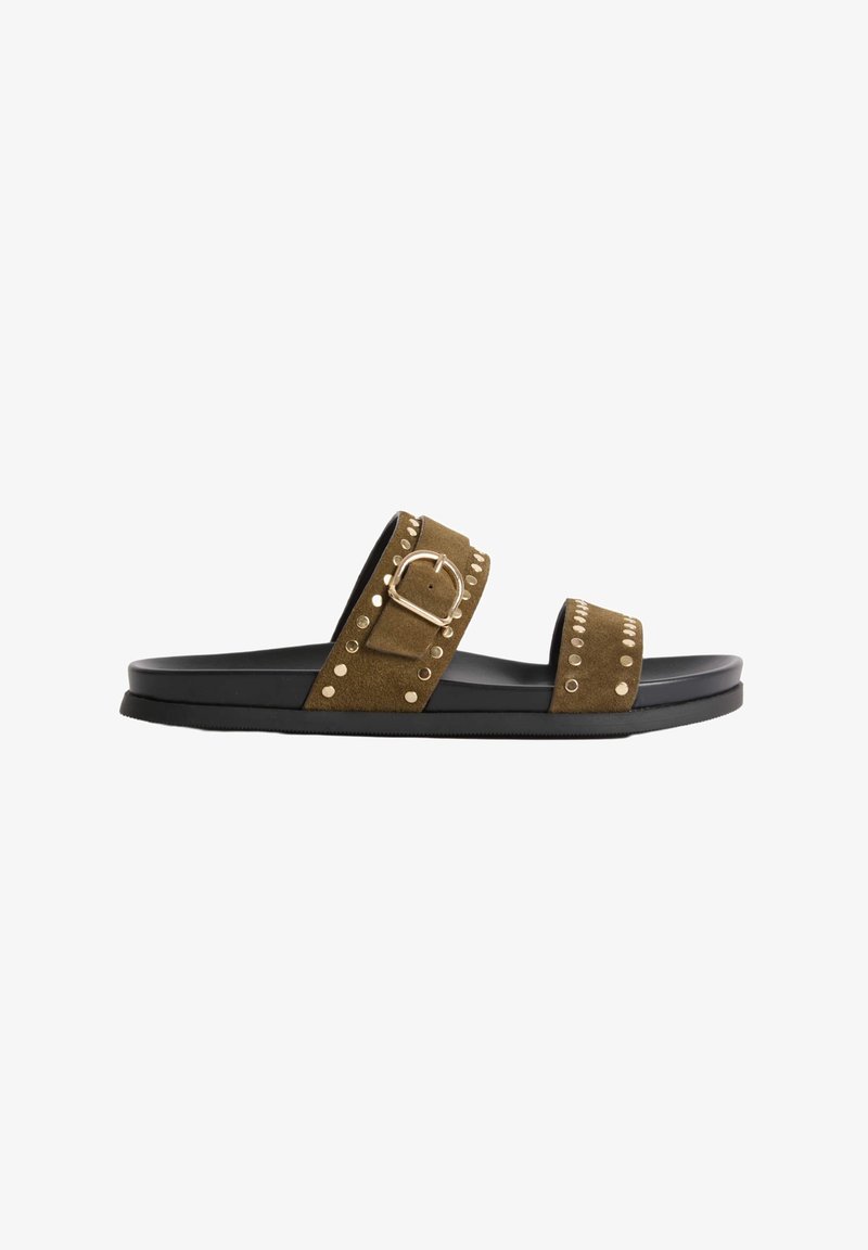Sandale slide en cuir suédé marron avec deux brides ornées de clous dorés, une bride ajustable avec une boucle dorée et une semelle plate noire.