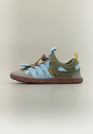 Sandale d'extérieur bleu clair et vert olive avec semelle marron, panneaux en mesh, lacets élastiques et languette jaune sur fond neutre.