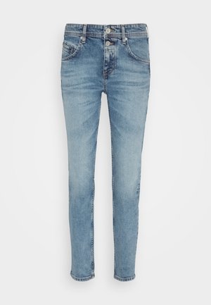 Hellblaue Jeans aus Denim mit schlanker Passform, fünf Taschen und einem Knopfverschluss. Antike Akzente an den Oberschenkeln sorgen für zusätzliche Textur.