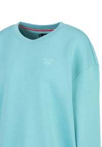 Licht turquoise sweatshirt gemaakt van zachte stof, met een ronde hals, verlaagde schouders en een klein wit logo detail op de borst.
