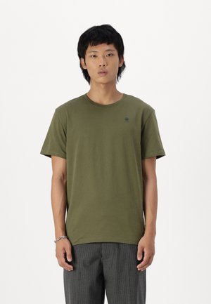 Olivengrønn bomull t-skjorte med korte ermer, rund hals og en liten logo på brystet. Glatt tekstur, slim fit-design.