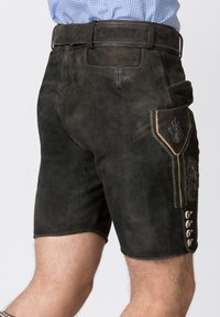 Pantaloni corti in pelle nera con finitura testurizzata, caratterizzati da ricami decorativi sulla tasca laterale e cinque bottoni decorativi sulla parte inferiore della gamba.