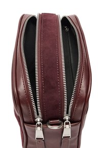 Bordowa torba z gładkiej skóry i zamszu. Posiada podwójne srebrne zamki, czarną podszewkę oraz metalowe akcenty u podstawy.