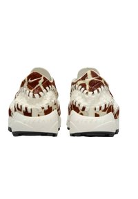 Sneakers med flätad vit och brun kohud, strukturerad design, vadderad krage och gummisula med svart grepp.