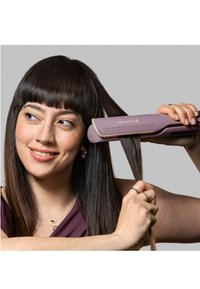 Remington hårstryker i lilla med en teksturert overflate, brukt på langt, rett hår. Har en avrundet kant og ergonomisk design.