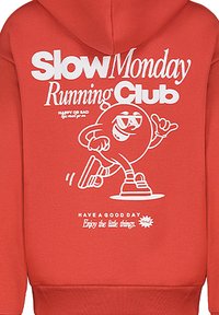 Rote Kapuzenpullover mit einem auffälligen weißen Grafikdruck, auf dem der Text "Slow Monday Running Club" und eine Cartoonfigur, die läuft, zu sehen ist.